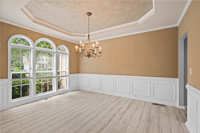 2595 Glaramara Ter, Cumming, GA 30041 - spare room featuring a tray ceiling, a chandelier, light wood-type flooring, a wainscoted wall, and crown molding