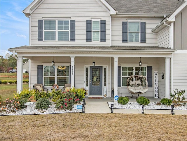 view of front of home with covered porch and a front lawn