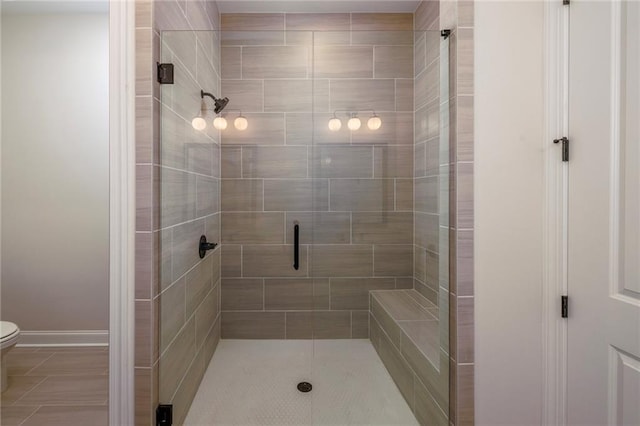 bathroom featuring toilet and a shower with shower door