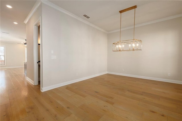 spare room featuring ceiling fan with notable chandelier, ornamental molding, and hardwood / wood-style floors