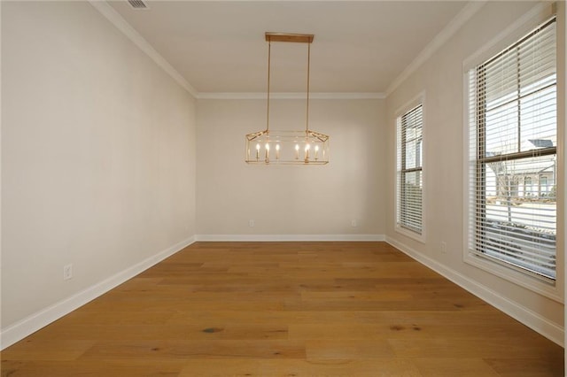 unfurnished dining area with an inviting chandelier, crown molding, and hardwood / wood-style flooring