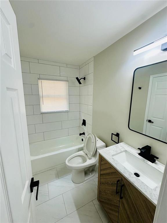 bathroom with toilet, shower / bath combination, marble finish floor, and vanity