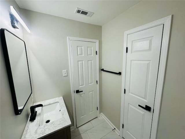 bathroom featuring marble finish floor, vanity, visible vents, and baseboards