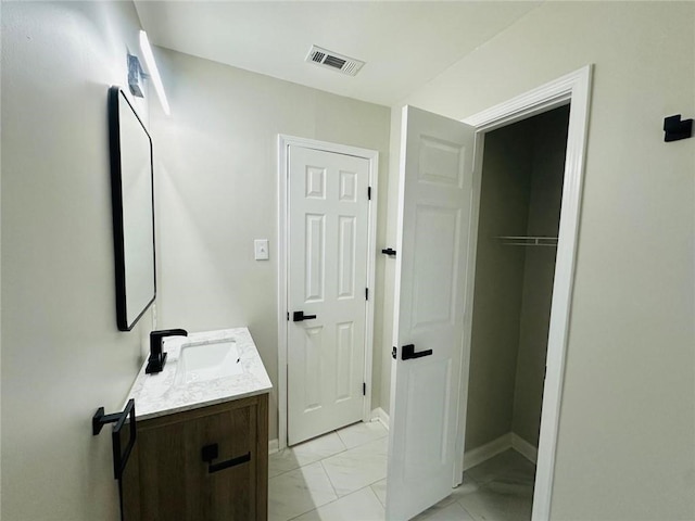 bathroom with marble finish floor, baseboards, visible vents, and vanity