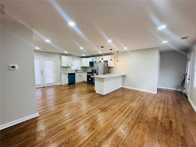 kitchen featuring a peninsula, range with gas stovetop, light countertops, decorative backsplash, and dishwasher