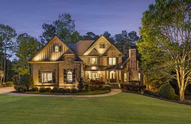 craftsman house with board and batten siding, a chimney, covered porch, and a front yard