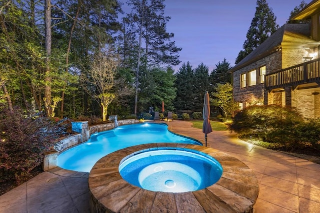 pool featuring a patio and an in ground hot tub