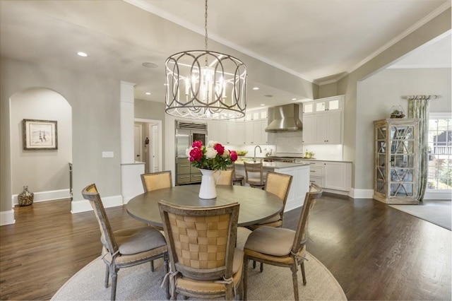 dining space with arched walkways, baseboards, a chandelier, and dark wood-style floors