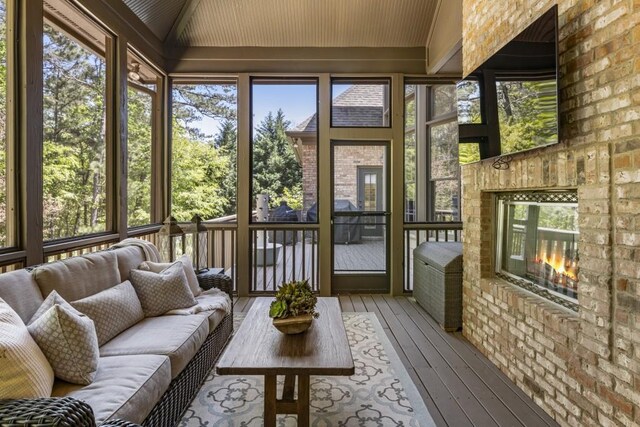 sunroom featuring an outdoor living space with a fireplace