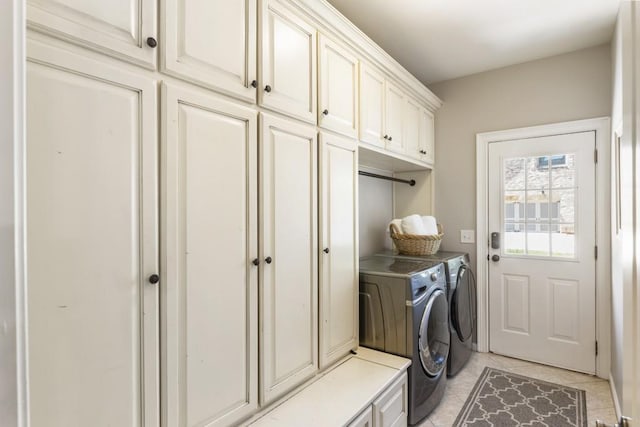 washroom with washer and dryer, cabinet space, and light tile patterned flooring
