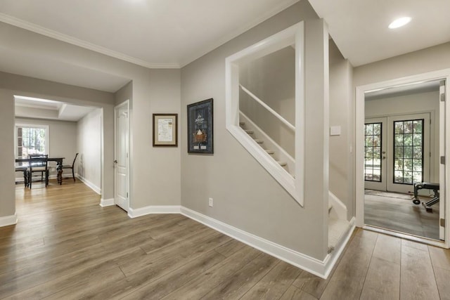 hall featuring baseboards, wood finished floors, and stairs