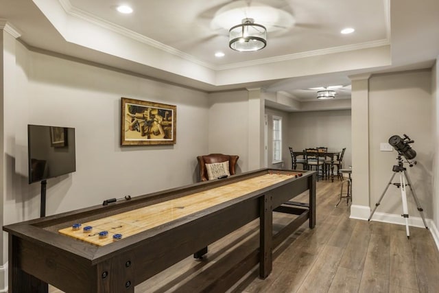 rec room featuring recessed lighting, hardwood / wood-style floors, a raised ceiling, ornamental molding, and baseboards