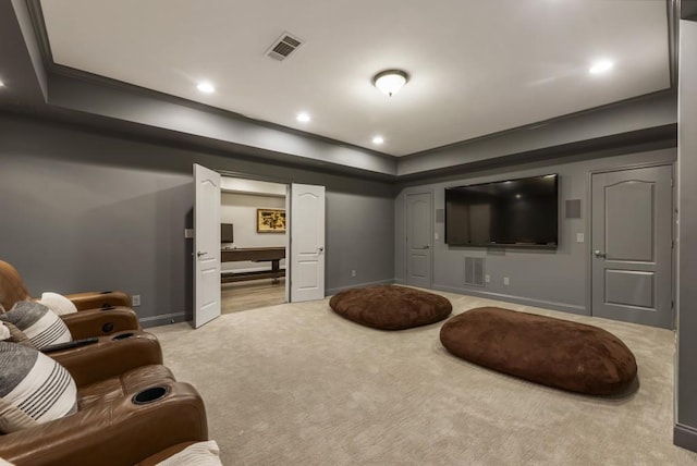 living area with a raised ceiling, visible vents, baseboards, and light carpet