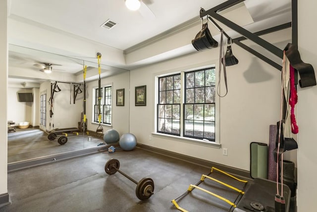 workout area with a ceiling fan, visible vents, a wealth of natural light, and crown molding