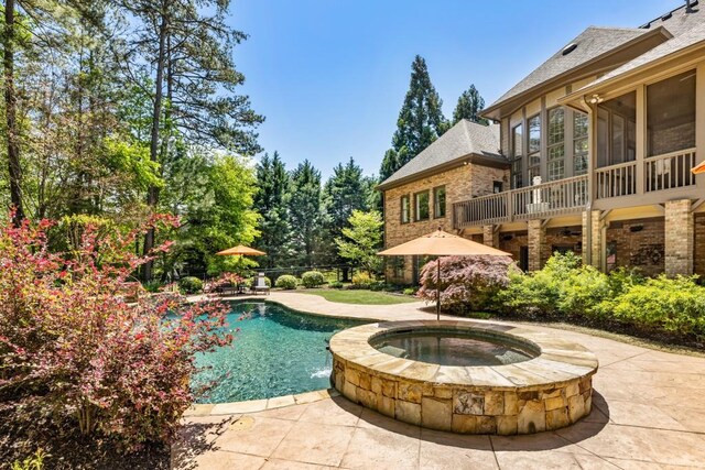 outdoor pool with a patio and an in ground hot tub