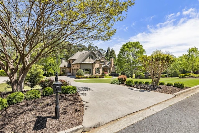 view of front of home featuring board and batten siding, brick siding, and a front yard