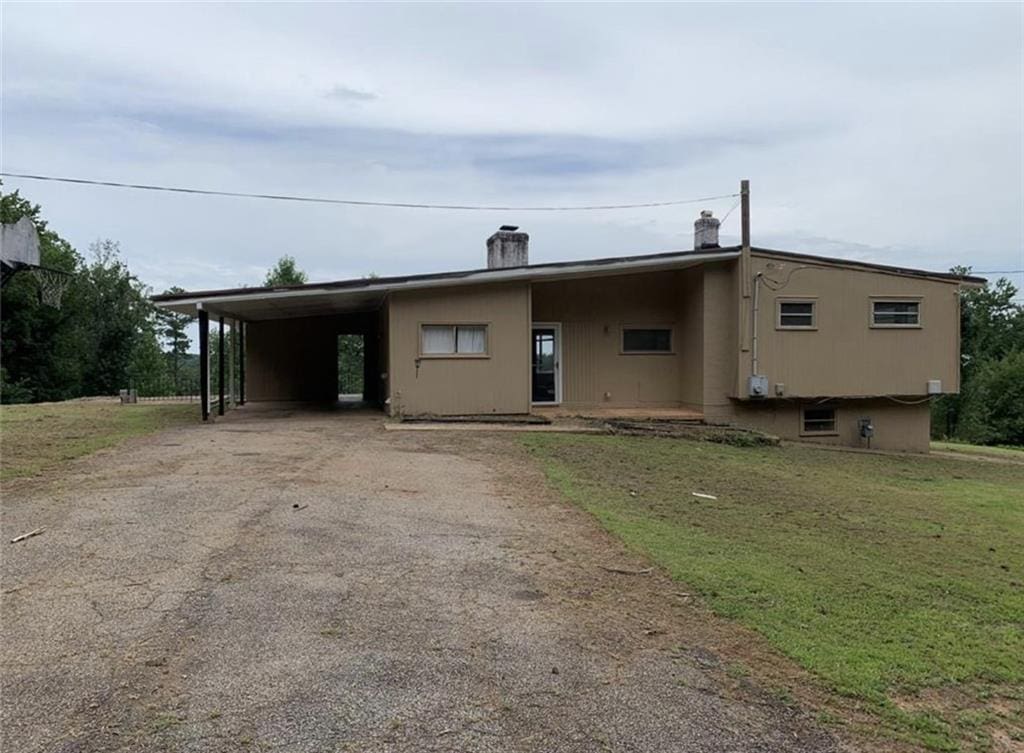 view of front of house with a front lawn and a carport