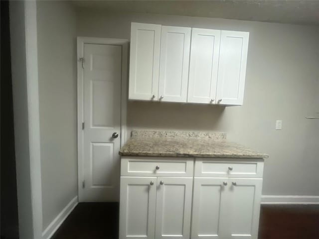 interior space with light stone counters and white cabinets