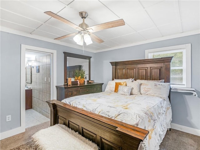 bedroom featuring light carpet, baseboards, a ceiling fan, and ensuite bathroom