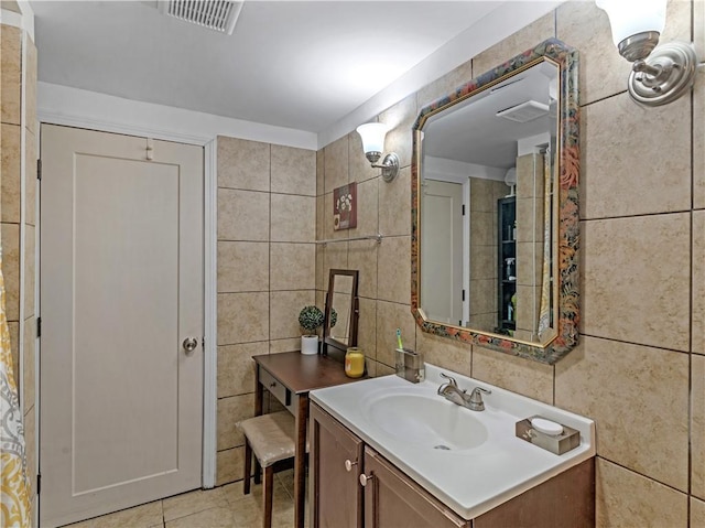 bathroom with visible vents, tile patterned flooring, vanity, and tile walls