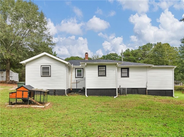 back of property with a lawn, a chimney, and cooling unit