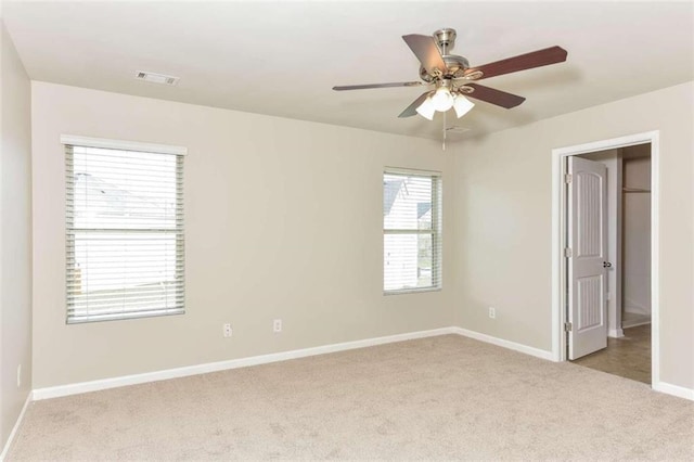 spare room featuring ceiling fan and light carpet