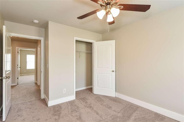 unfurnished bedroom with light colored carpet, a closet, and ceiling fan