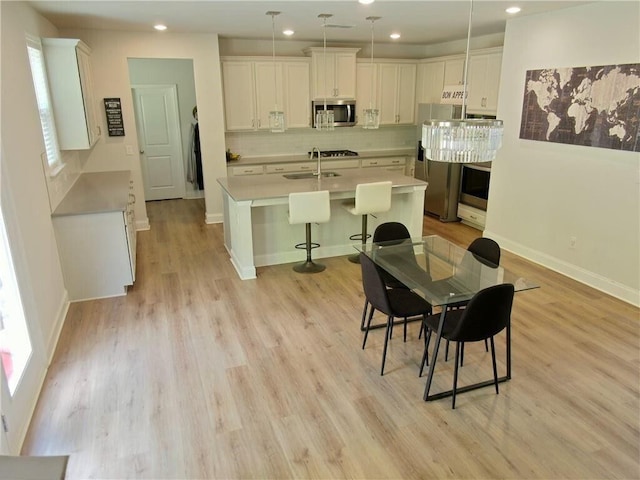 dining space featuring sink, a wealth of natural light, and light hardwood / wood-style flooring