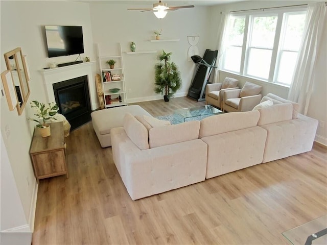 living room featuring ceiling fan and light hardwood / wood-style floors