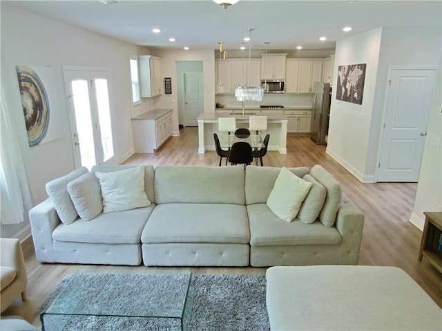 living room with light wood-type flooring and sink