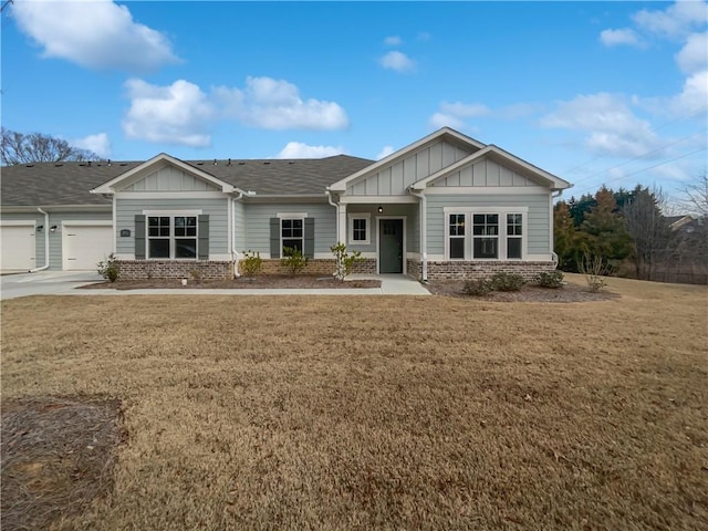 craftsman inspired home with a garage, a front yard, board and batten siding, and brick siding