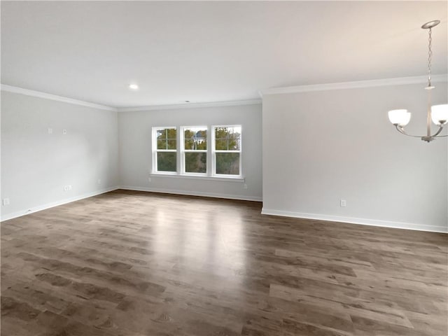 empty room with ornamental molding, dark wood-style flooring, baseboards, and an inviting chandelier