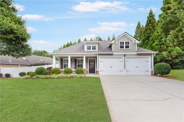 view of front of house with covered porch, fence, driveway, and a front lawn