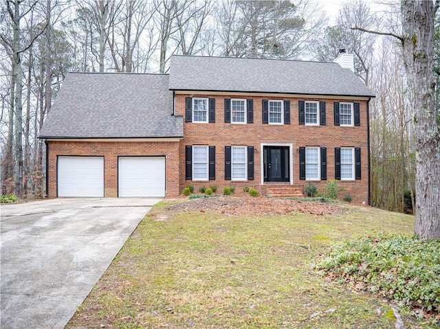 colonial-style house featuring a front yard and a garage