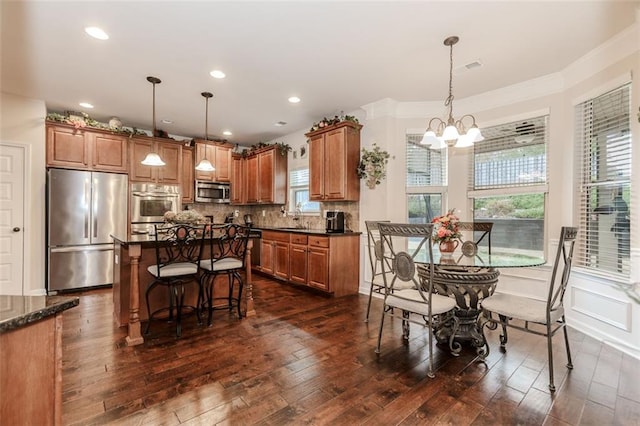 kitchen featuring decorative light fixtures, dark hardwood / wood-style flooring, stainless steel appliances, and a notable chandelier