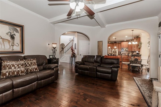 living room with beam ceiling, ceiling fan with notable chandelier, dark hardwood / wood-style floors, and ornamental molding