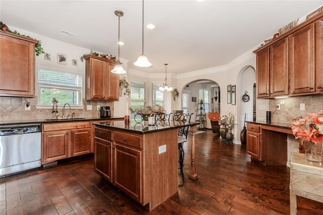 kitchen featuring a center island, sink, hanging light fixtures, stainless steel dishwasher, and dark hardwood / wood-style flooring