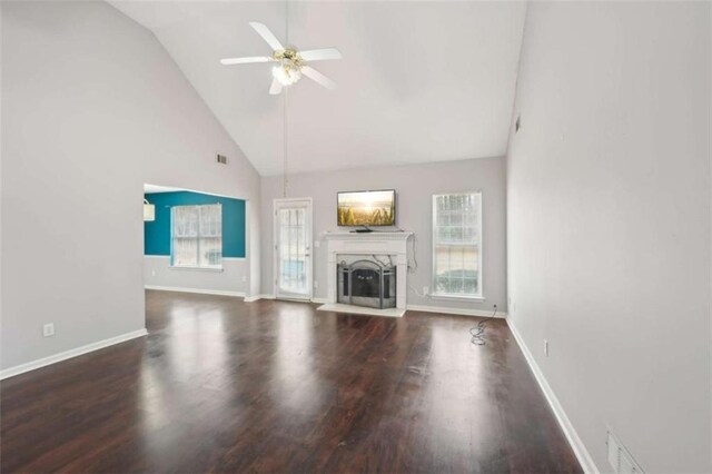 unfurnished living room featuring a fireplace, baseboards, a ceiling fan, and wood finished floors