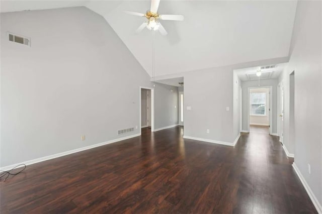 unfurnished living room featuring visible vents, attic access, wood finished floors, and a ceiling fan