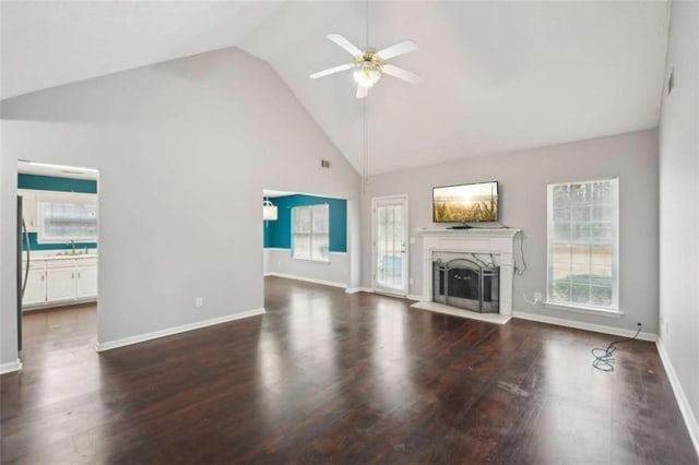 unfurnished living room featuring a healthy amount of sunlight, a fireplace, a ceiling fan, and wood finished floors