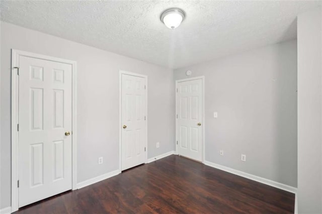 unfurnished bedroom featuring wood finished floors, baseboards, and a textured ceiling