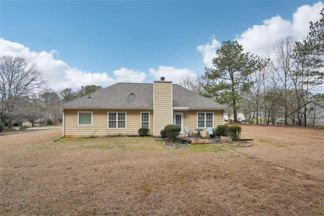 back of property featuring a yard, a patio, and a chimney