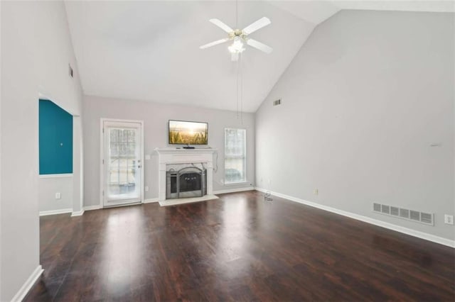 unfurnished living room with visible vents, plenty of natural light, ceiling fan, and a fireplace