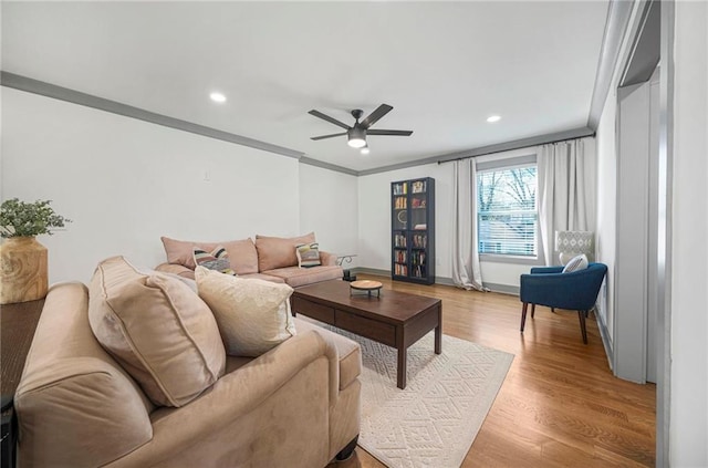 living room featuring crown molding, ceiling fan, and light hardwood / wood-style flooring