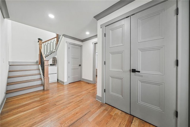 hallway featuring crown molding, wood-type flooring, and an inviting chandelier