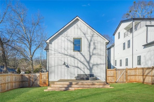 back of property featuring a deck and a lawn