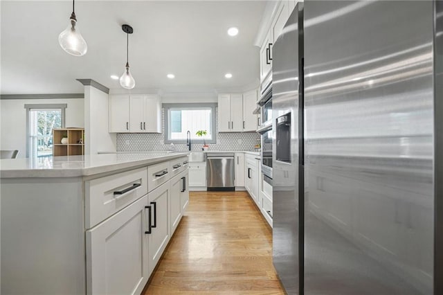 kitchen featuring stainless steel appliances, a center island, and white cabinets