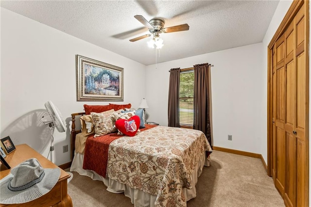 carpeted bedroom featuring a textured ceiling, ceiling fan, and a closet