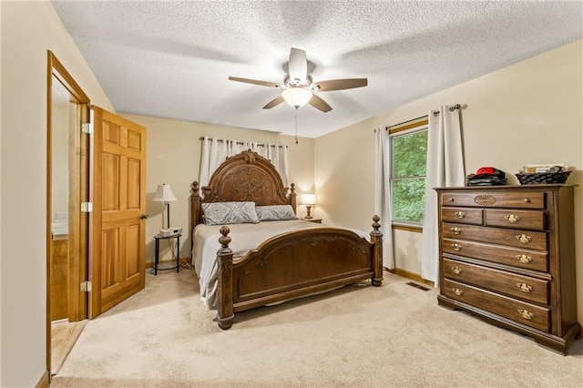 bedroom with light carpet, ceiling fan, and a textured ceiling