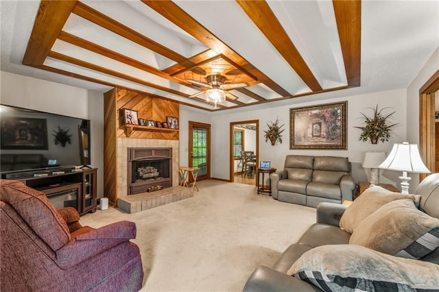 living room with light colored carpet, a tile fireplace, wooden walls, and ceiling fan